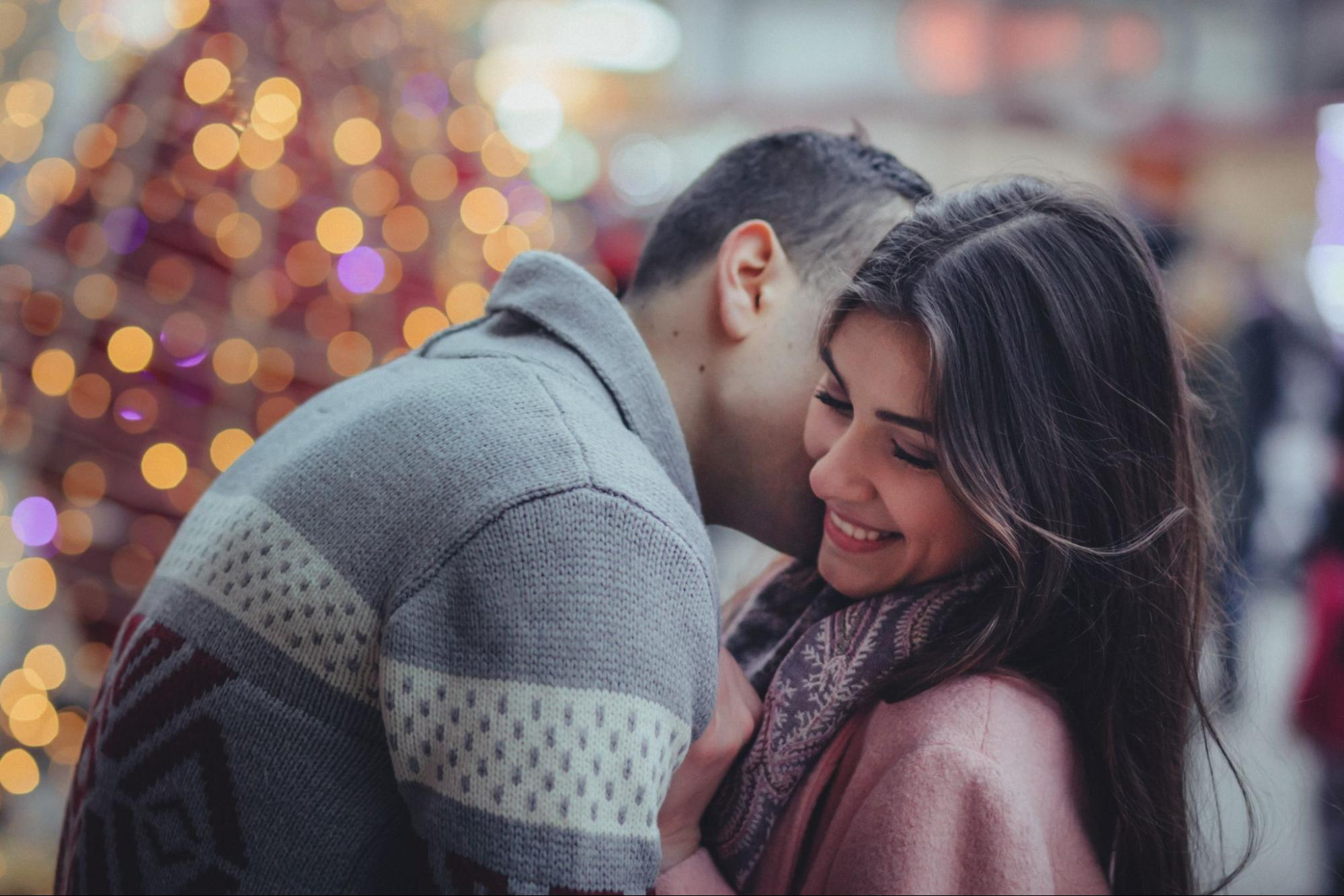 A couple celebrates their anniversary with a public kiss during wintertime.