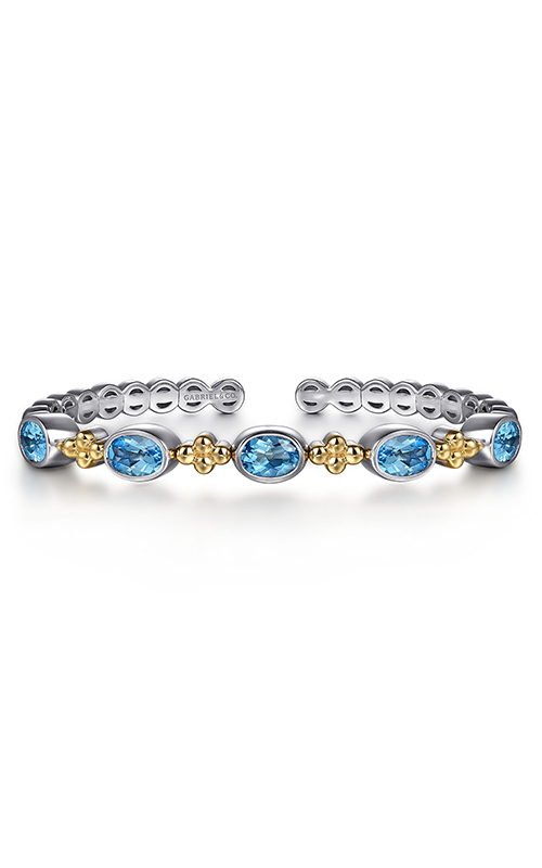 A yellow gold and silver bracelet with oval blue topaz