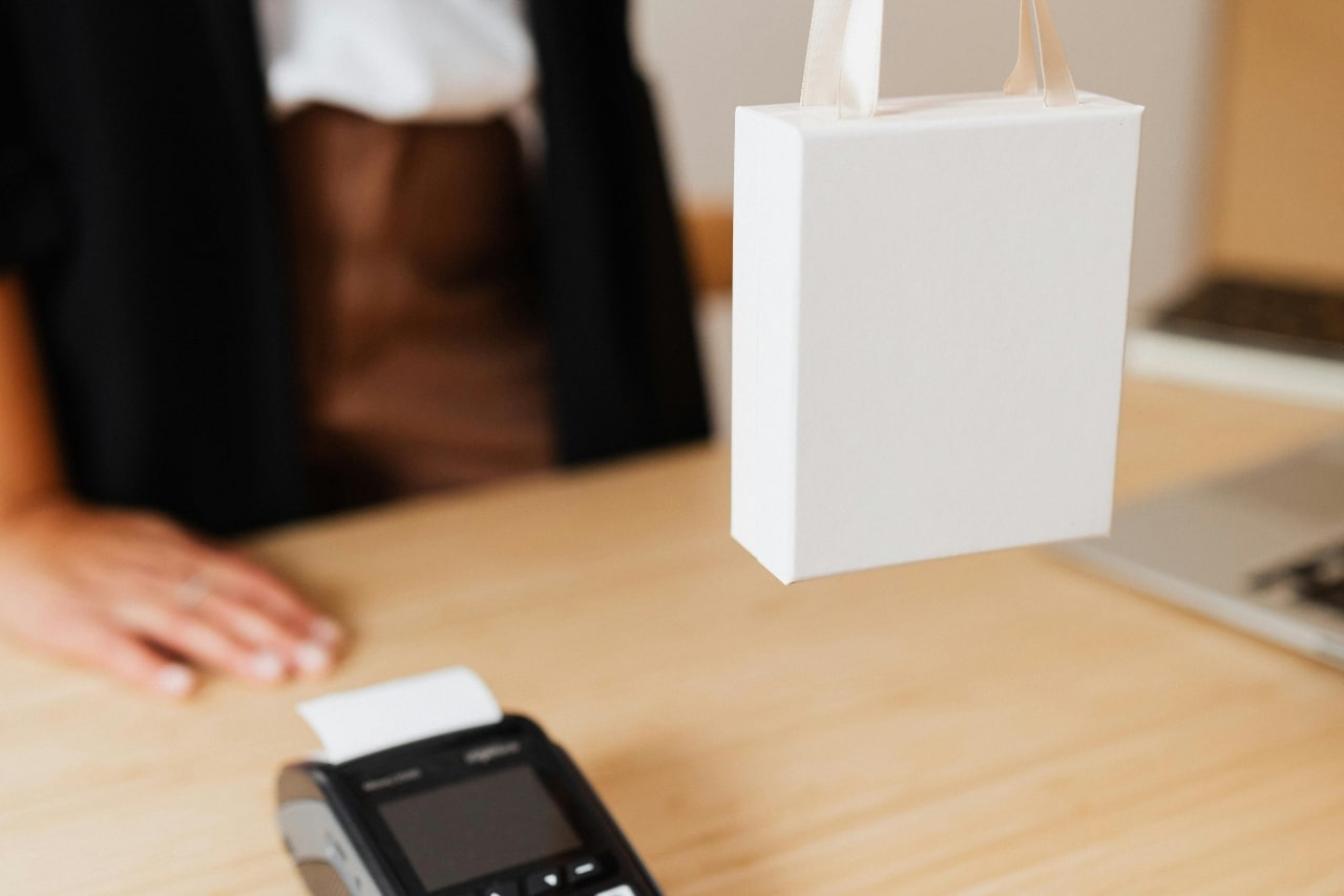 a transaction happening at a counter with a white gift bag