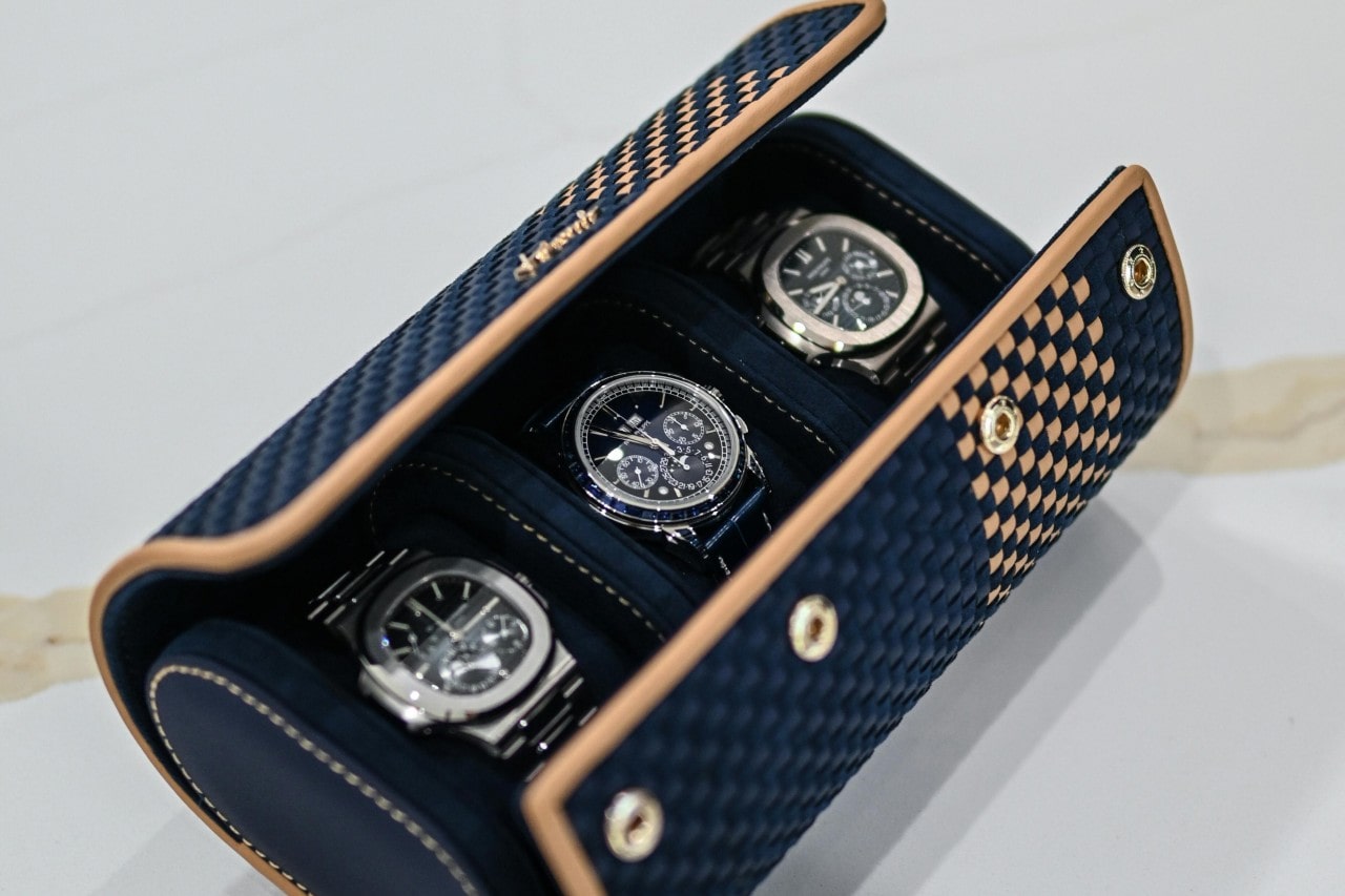 A refined blue case displaying three timepieces, each with unique design and exceptional craftsmanship.
