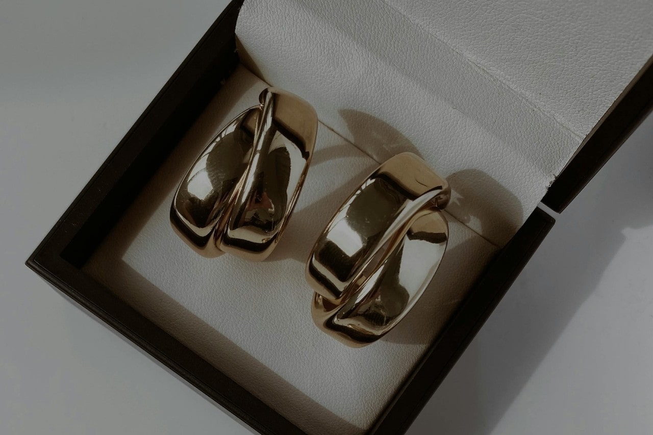 a pair of silver hoop earrings in a black and white gift box