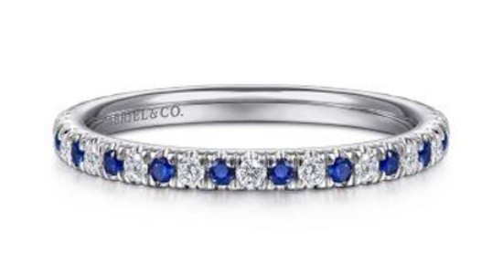 a white gold wedding band featuring diamonds and blue sapphires
