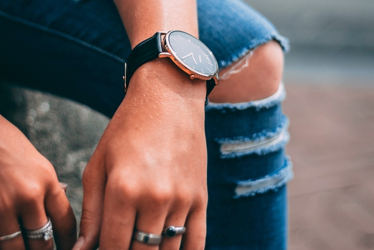 lady’s hands wearing a luxury watch and fashion rings