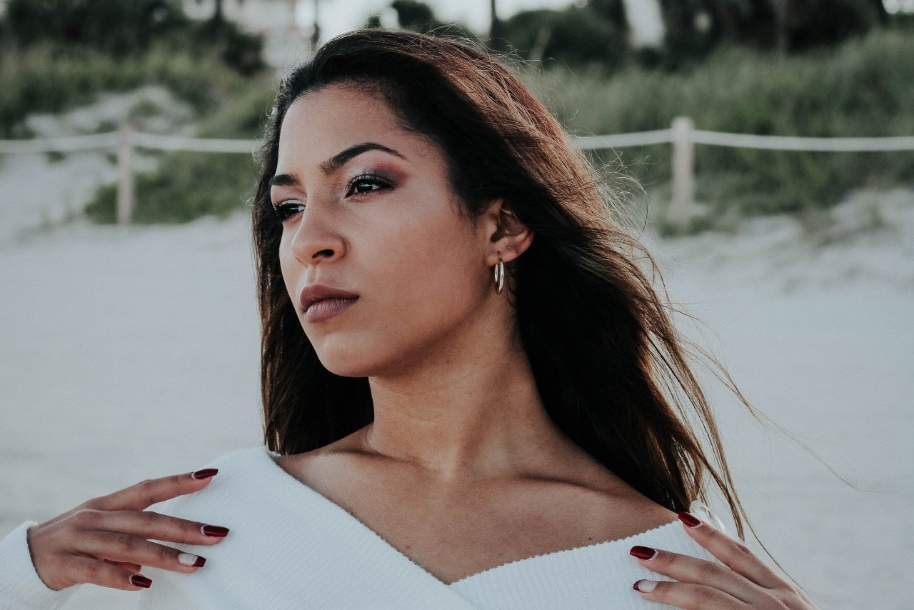 lady wearing a white sweater and white gold hoop earrings by Simon G. lady wearing a white sweater and white gold hoop earrings by Simon G.