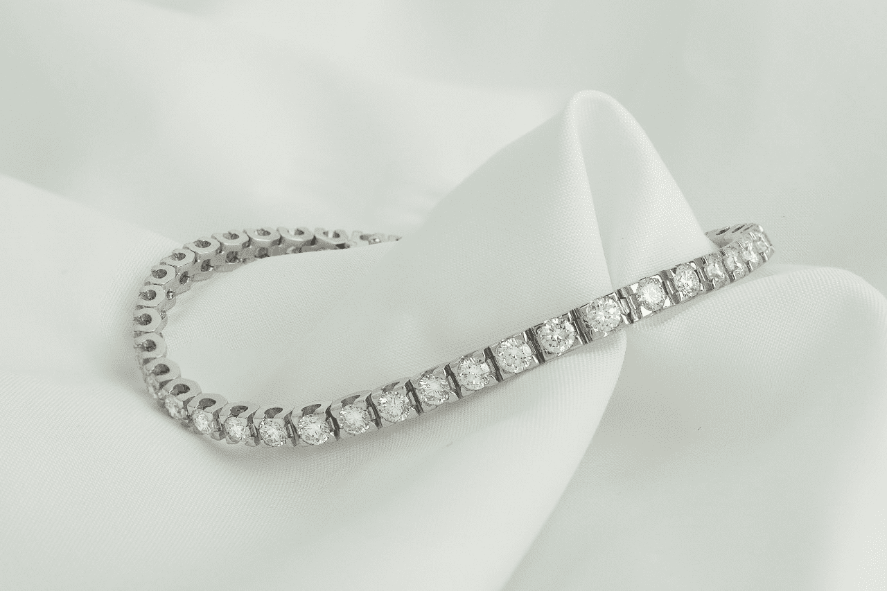 a white gold diamond bracelet on a piece of white fabric