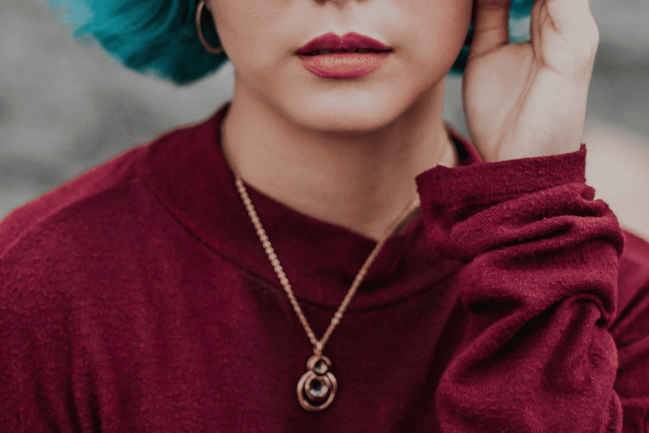 lady wearing a red sweater and a rose gold fashion necklace