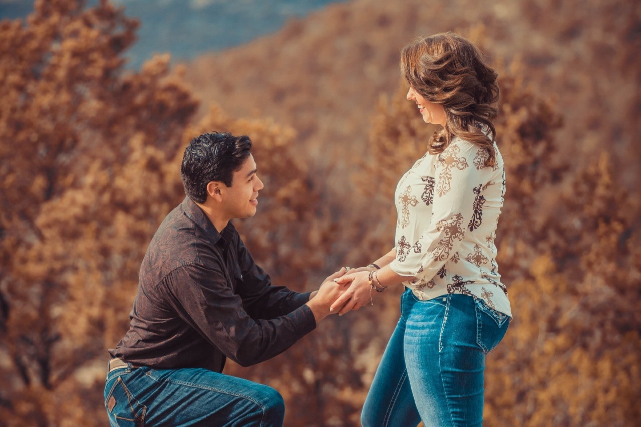 A man proposing to his partner among colorful autumn foliage. A man proposing to his partner among colorful autumn foliage.