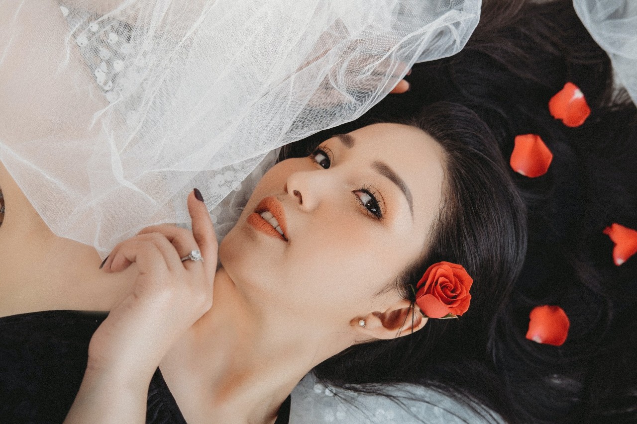A close-up of a bride-to-be laying on her veil, roses in her hair and an engagement ring on her hand. A close-up of a bride-to-be laying on her veil, roses in her hair and an engagement ring on her hand.