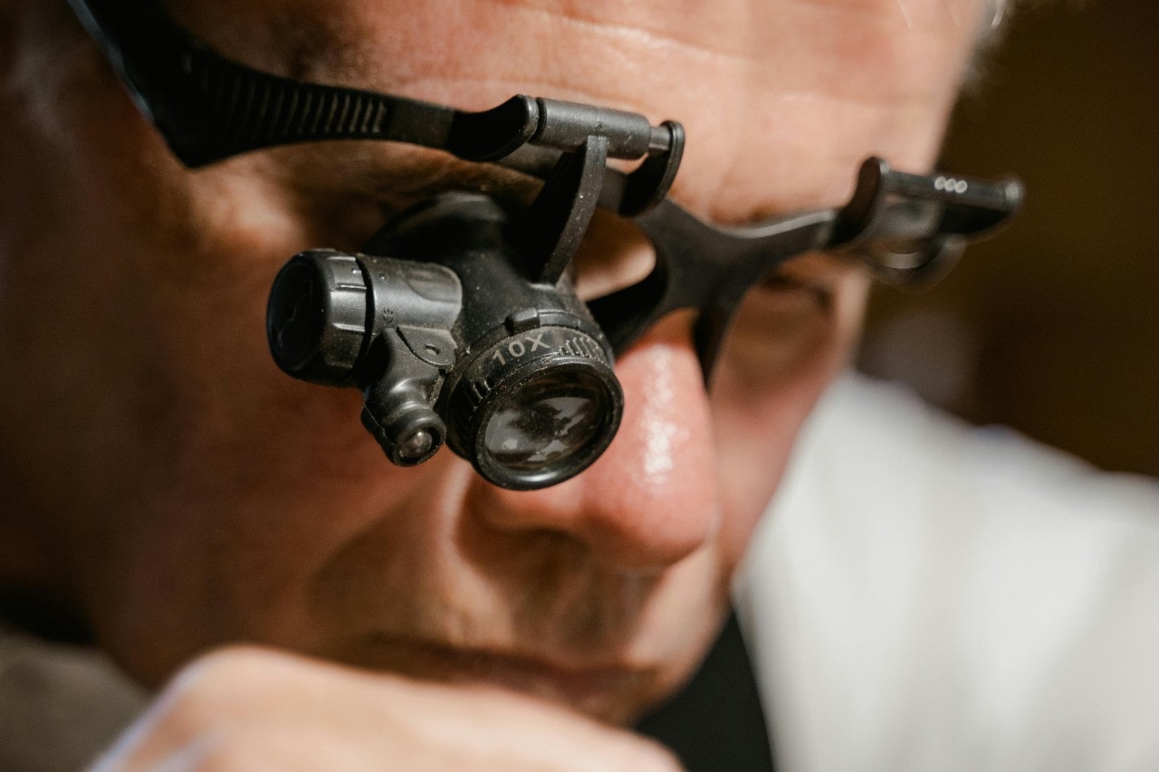 A close up of a jeweler wearing a black magnifying lens.