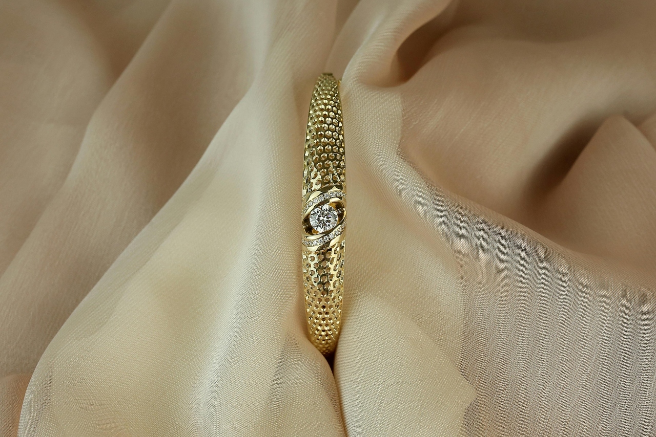 A close-up of a simple yet distinctive engagement ring nestled within beige taffeta. A close-up of a simple yet distinctive engagement ring nestled within beige taffeta.
